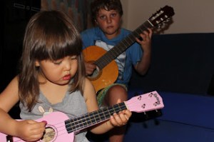 Mia and RJ learning guitar