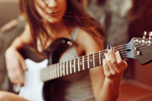Woman's hands playing acoustic guitar, close up